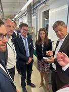 vier Männer und eine Frau lauschen einem Redner