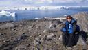 Frau sitzt am Meer (Ross Sea) mit Eisbergen im Hintergrund