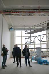 Männer schauen an die Decke auf einer Baustelle 