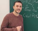 ein Mann vor einer Tafel mit Formeln 